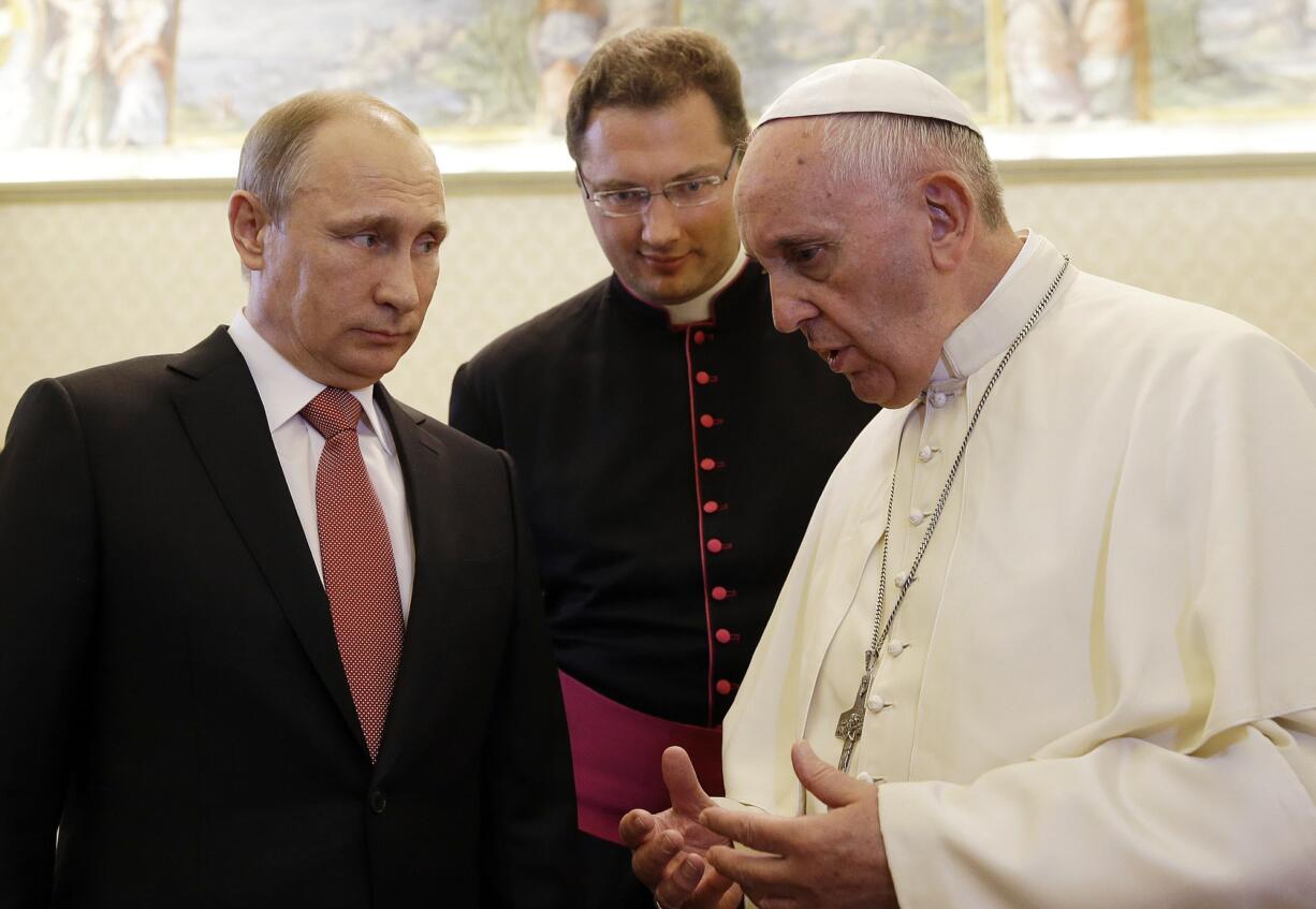 Russian President Vladimir Putin, left, listens to Pope Francis on Wednesday at the Vatican.