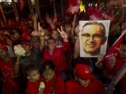 Supporters of presidential candidate Salvador Sanchez Ceren hold up an image of Oscar Arnulfo Romero as they celebrate March 9 after partial results were announced by election authorities in San Salvador, El Salvador.