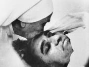 Associated Press files
A nun plants a kiss on the forehead of Archbishop Oscar Arnulfo Romero of El Salvador on March 23, 1980, at the Hospital of Divine Providence. Pope Francis decreed Tuesday that the slain Salvadoran archbishop was killed in 1980 out of hatred for his Catholic faith, approving a martyrdom declaration that sets the stage for his beatification.