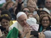 Pope Francis kisses a baby as he arrives for his weekly general audience in October in St.