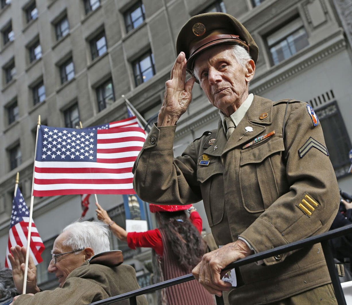 Frank Milano, 92, salutes from a float of World War II veterans Tuesday during the annual Veterans Day parade in New York.