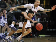 Portland's Alec Wintering, left, chases a loose ball against Saint Mary's Kerry Carter during the second half in the quarterfinals of the West Coast Conference tournament Saturday, March 7, 2015, in Las Vegas. Portland won 69-52.