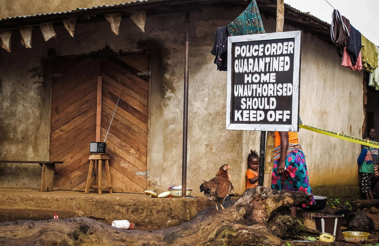 A child stands Oct. 22 near a sign advising of a quarantined home in an effort to combat the spread of the Ebola virus in Port Loko, Sierra Leone.