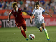 China's Pang Fengyue (3) chases United States' Carli Lloyd (10) during the second half of a quarterfinal match in the FIFA Women's World Cup soccer tournament, Friday, June 26, 2015, in Ottawa, Ontario, Canada.