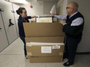 In this May 1, 2015 photo, Michael Labrie, director of collections and exhibitions at the Walt Disney Family Museum, right, and assistant registrar Jamie O'Keefe look through a bin of Salvador Dali art in a collections room at the Disney museum in San Francisco. Besides his love of wholesome entertainment, Walt Disney also had an appreciation for the eccentric that led to a short-lived partnership and decades-long friendship with surrealistic artist Salvador Dali.