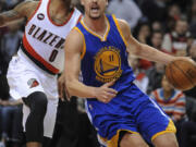 Golden State Warriors' Klay Thompson (11) drives against Portland Trail Blazers' Damian Lillard (0) during the first half of an NBA basketball game in Portland, Ore., Tuesday, March 24, 2015.