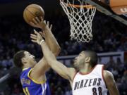 Golden State Warriors guard Klay Thompson, left, goes to the hoop against Portland Trail Blazers forward Nicolas Batum during the first half in Portland, Ore., Sunday, Nov. 2, 2014.