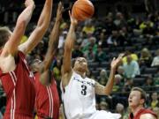 Oregon's Joseph Young, center, shoots against Washington State's Josh Hawkinson, left, Ike Iroegbu and Brett Boese, right, during the first half in Eugene, Ore., Sunday, Feb. 8, 2015.