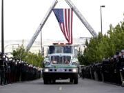 A U.S. Forest Service truck passes as firefighters salute the arrival of a motorcade for a memorial service for three firefighters killed in a wildfire, Sunday, Aug. 30, 2015, in Wenatchee, Wash. Richard Wheeler, Andrew Zajac and Thomas Zbyszewski died Aug. 19 in a fire near Twisp, Wash.
