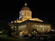 Vehicles remain parked outside the Legislative Building just after midnight, Wednesday at the Capitol in Olympia, as Tuesday's legislative session continued into the night. Washington Gov.