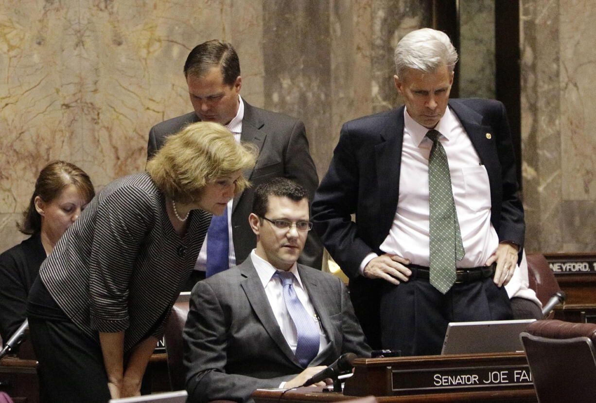 Senators gather Thursday in Olympia to watch a vote count on the Senate floor on a measure that would delay full implementation of an initiative to reduce class sizes.