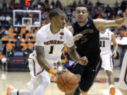 Oregon State guard Gary Payton II, left, drives on Washington guard Nigel Williams-Goss during the second half  in Corvallis, Ore., Sunday, Feb. 8, 2015. Payton led Oregon State in scoring with 17 points as they defeated Washington 64-50.