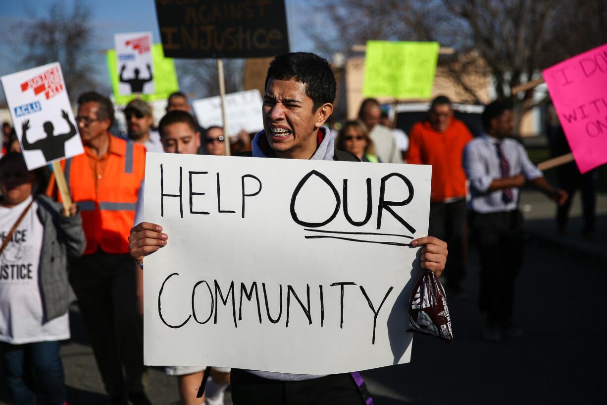 A marcher holds a sign Saturday during a rally for Antonio Zambrano-Montes in Pasco. Zambrano-Montes was shot and killed Feb.