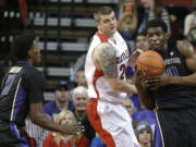 Washington's Shawn Kemp Jr., right, tries to get a pass off to Mike Anderson, left, around the defense of Seattle's Jack Crook, center, during the second half Friday, Nov. 21, 2014, in Seattle. Washington won 63-48. (AP Photo/Ted S.