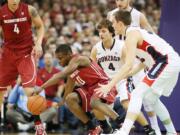 Washington State's Ike Iroegbu (0) goes after a loose ball against Gonzaga's Kyle Wiltjer, right, and Kevin Pangos during the first half in Spokane on Wednesday.