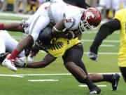 Washington State's Carl Winston (3) is tackled by an Oregon defender in the first half Saturday.