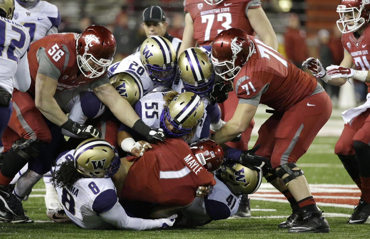 Washington State wide receiver Vince Mayle (1) is tackled by Washington defensive lineman Danny Shelton (55) and a host of other players in the first half Saturday in Pullman.