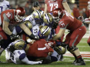 Washington State wide receiver Vince Mayle (1) is tackled by Washington defensive lineman Danny Shelton (55) and a host of other players in the first half Saturday in Pullman.