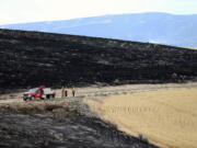 Three Chewack Fire Suppression workers stand Sunday near ground burned by the Douglas County Complex Fire near Waterville.