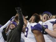 Washington coach Chris Petersen, left, celebrates with players Saturday, Nov. 29, 2014, in Pullman, after Washington defeated Washington State 31-13 in the Apple Cup. (AP Photo/Ted S.