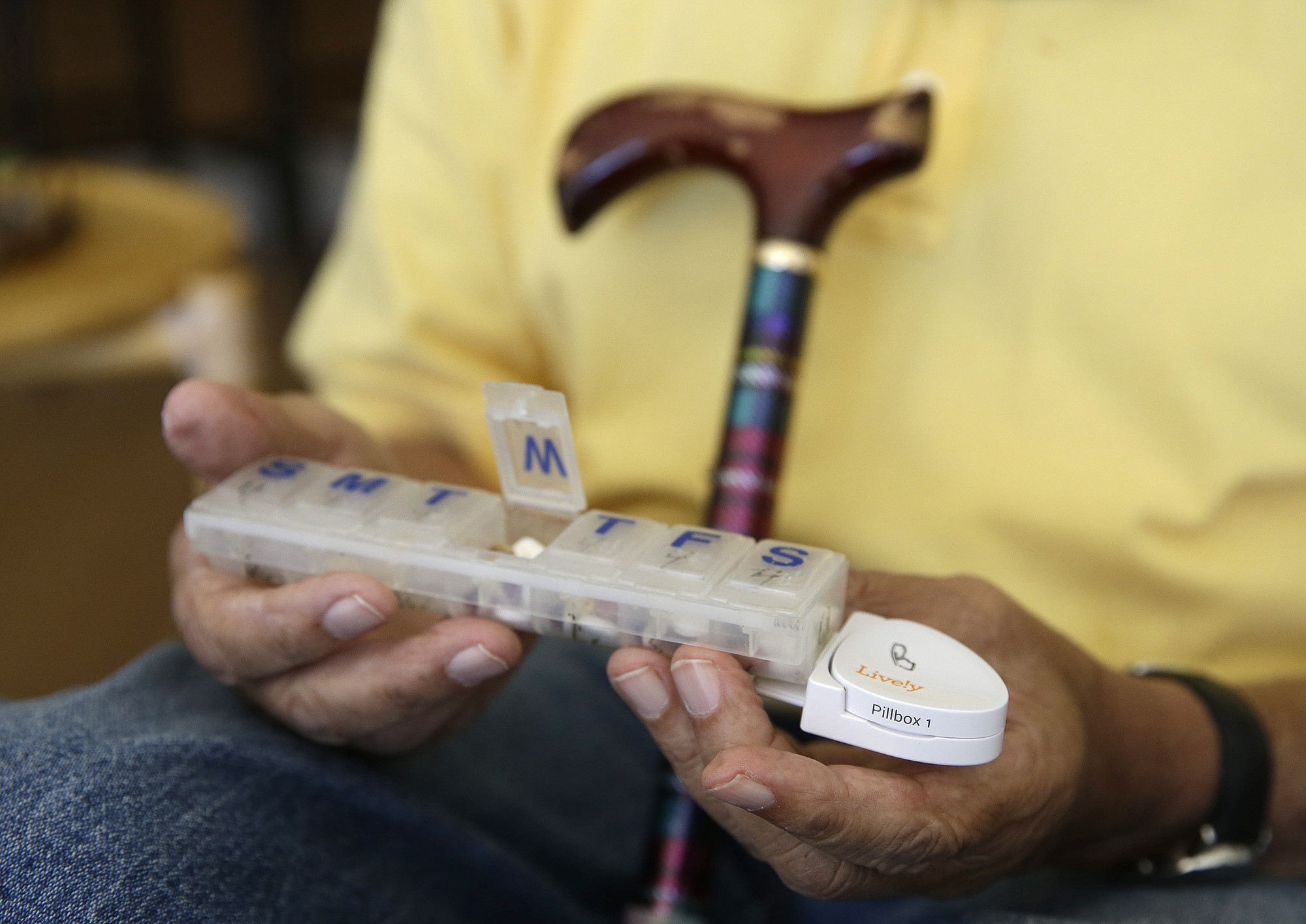 Bill Dworsky holds his pill container with a motion sensor attached.