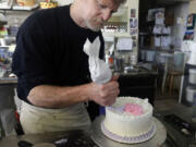 Masterpiece Cakeshop owner Jack Phillips decorates a cake inside his store in Lakewood, Colo., on March 10, 2014.