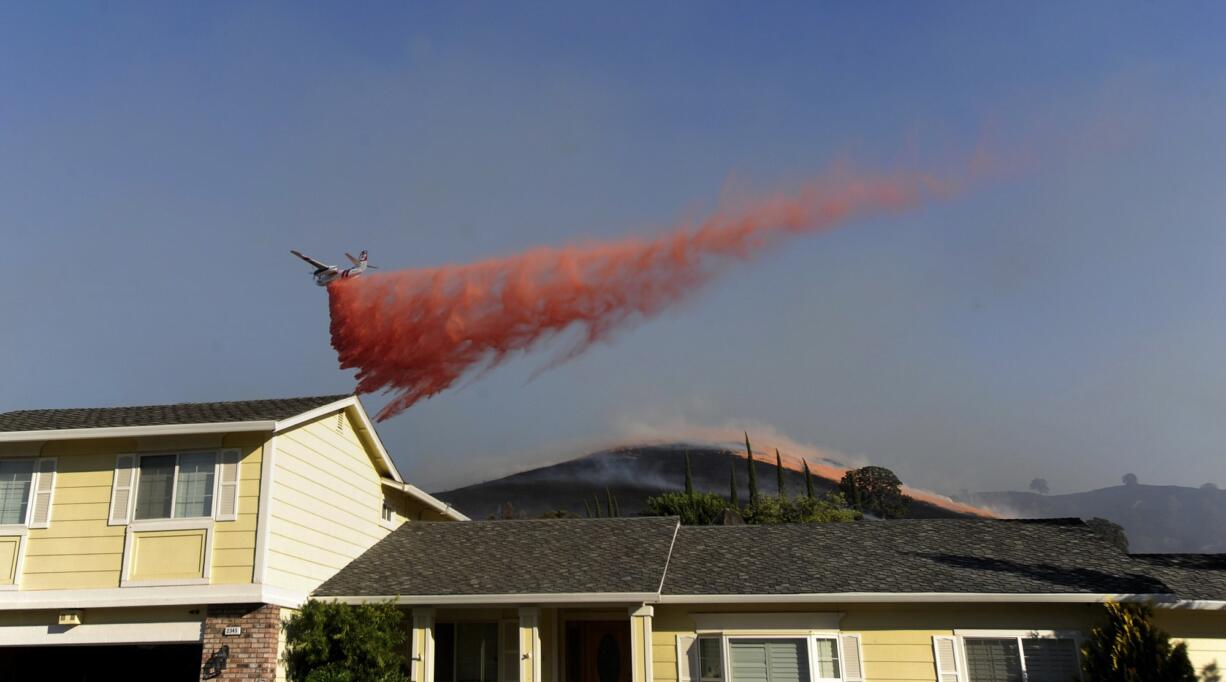 Fire retardant is dropped on hills behind evacuated homes on Foothill Drive in Antioch, Calif., on Wednesday.