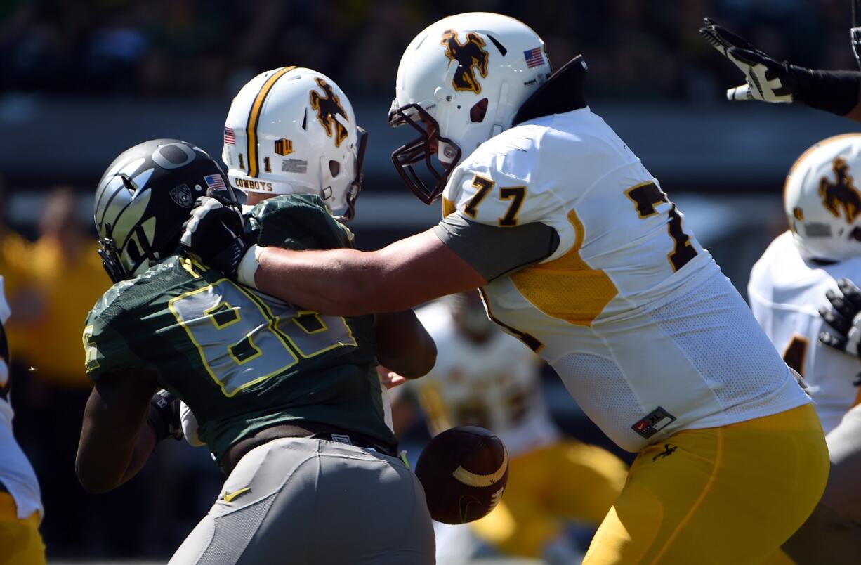 Oregon linebacker Torrodney Prevot (86) forces a fumble as he sacks  Wyoming quarterback Colby Kirkegaard (11) during the third quarter.