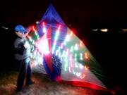 Mike, who asked that his last name not be published, prepares to fly his large, electronic Chinese-made kite Monday night in Fisher's Landing.