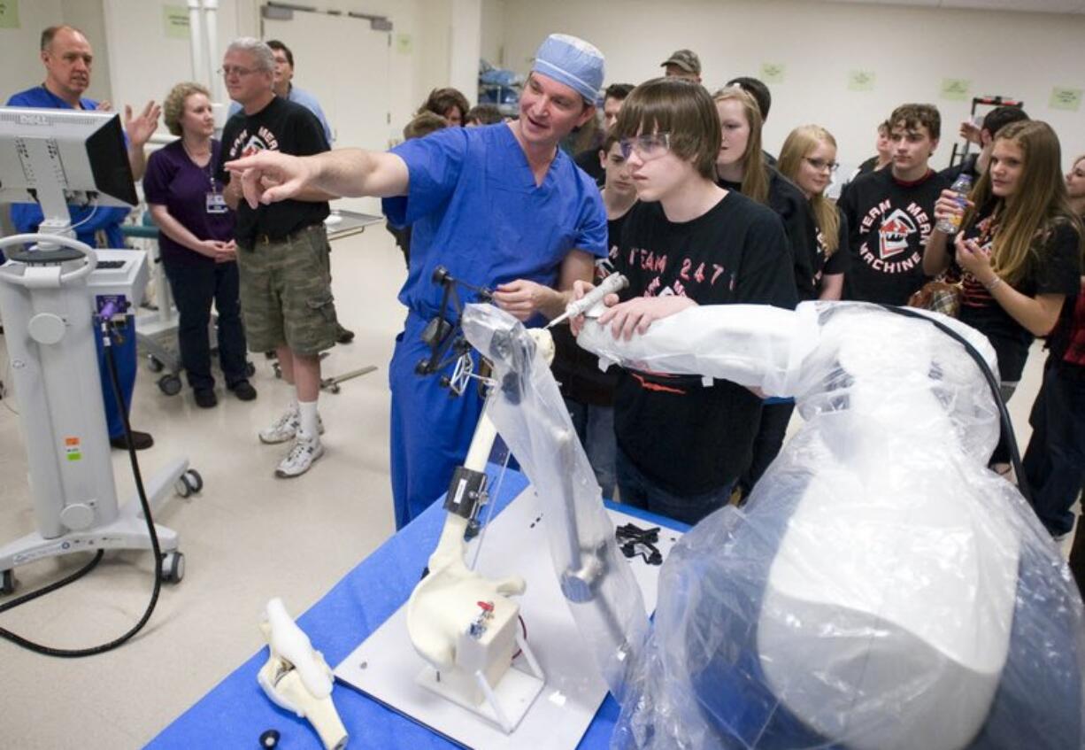 Keefe Koenig, 16, from Hockinson High School, gets a chance to perform a mock surgery with instruction from Dr.