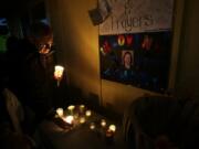 Peter Kritsch, the brother of slain park ranger Margaret Anderson, pictured on the poster at right, lights a candle in memory of his sister during an evening vigil for Anderson on Sunday in Eatonville, Wash. Anderson was killed by a gunman on Jan. 1 during a traffic stop where she worked at Mount Rainier National Park. Clark County Sheriff's Office Sgt.