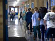 A teacher leads students down a hallway at Ellsworth Elementary on August 31.