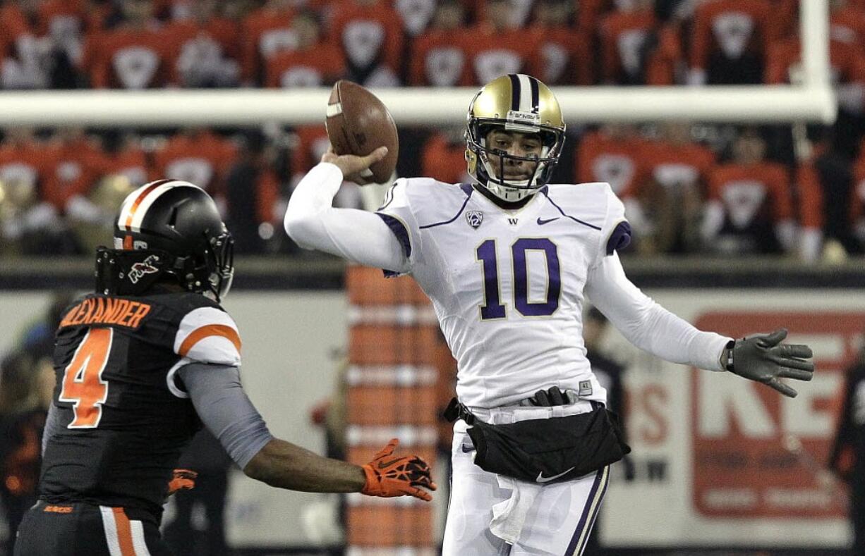 Washington quarterback Cyler Miles, right, passes as Oregon State defender D.J. Alexander in a Pac-12 game on Nov. 23, 2013.