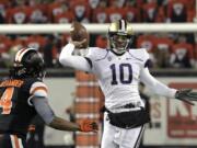 Washington quarterback Cyler Miles, right, passes as Oregon State defender D.J. Alexander in a Pac-12 game on Nov. 23, 2013.