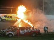 Emergency workers try to put out a fire after Juan Pablo Montoya's car struck the truck during the NASCAR Daytona 500 auto race at Daytona International Speedway in Daytona Beach, Fla., Monday.