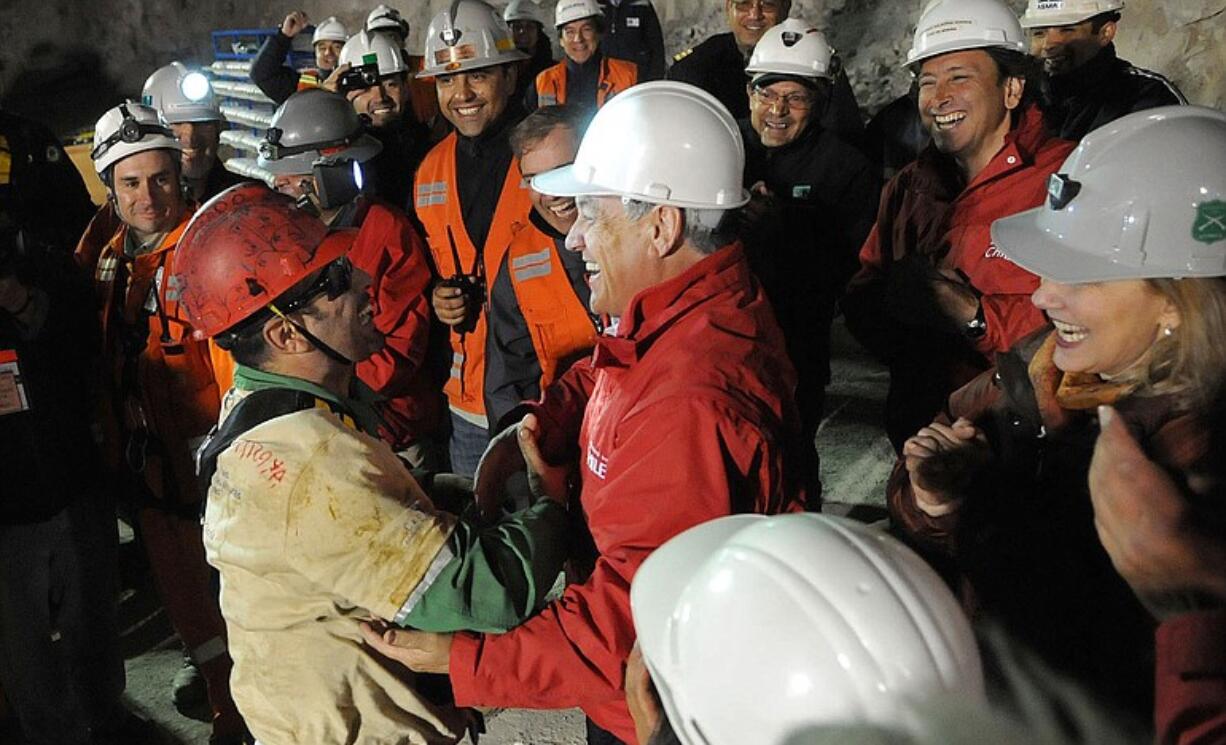 Chile's President Sebastian Pinera, center, greets rescued miner Mario Sepulveda after Sepulveda was rescued from the collapsed San Jose gold and copper mine where he was trapped with 32 other miners for over two months near Copiapo, Chile, early Wednesday.