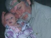 Chris Brewster holds his granddaughter in a photo taken before he was attacked in April 2015. Brewster, 55, of Vancouver died June 7 from his injuries.