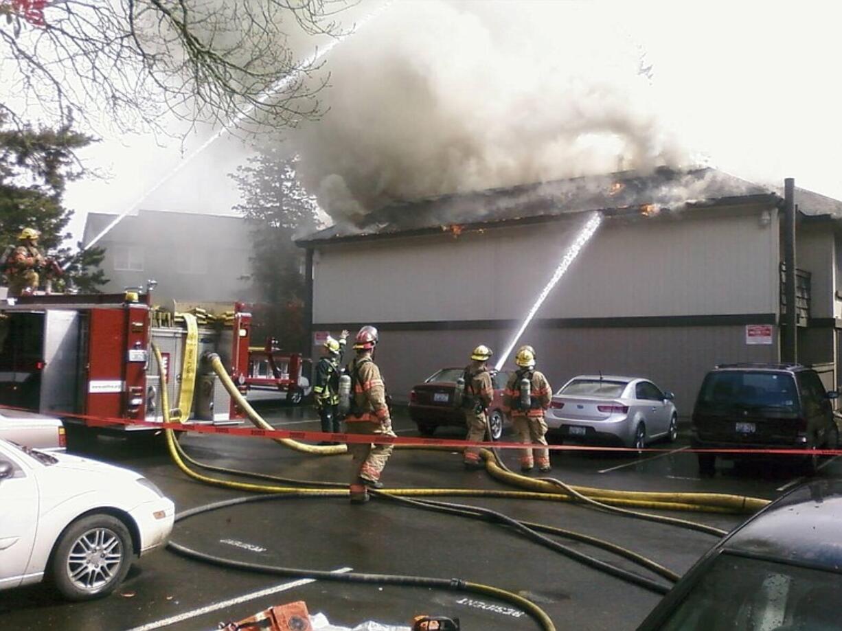 Flames can be seen coming from the roof more than an hour after the fire was reported at the Rolling Creek Apartments.