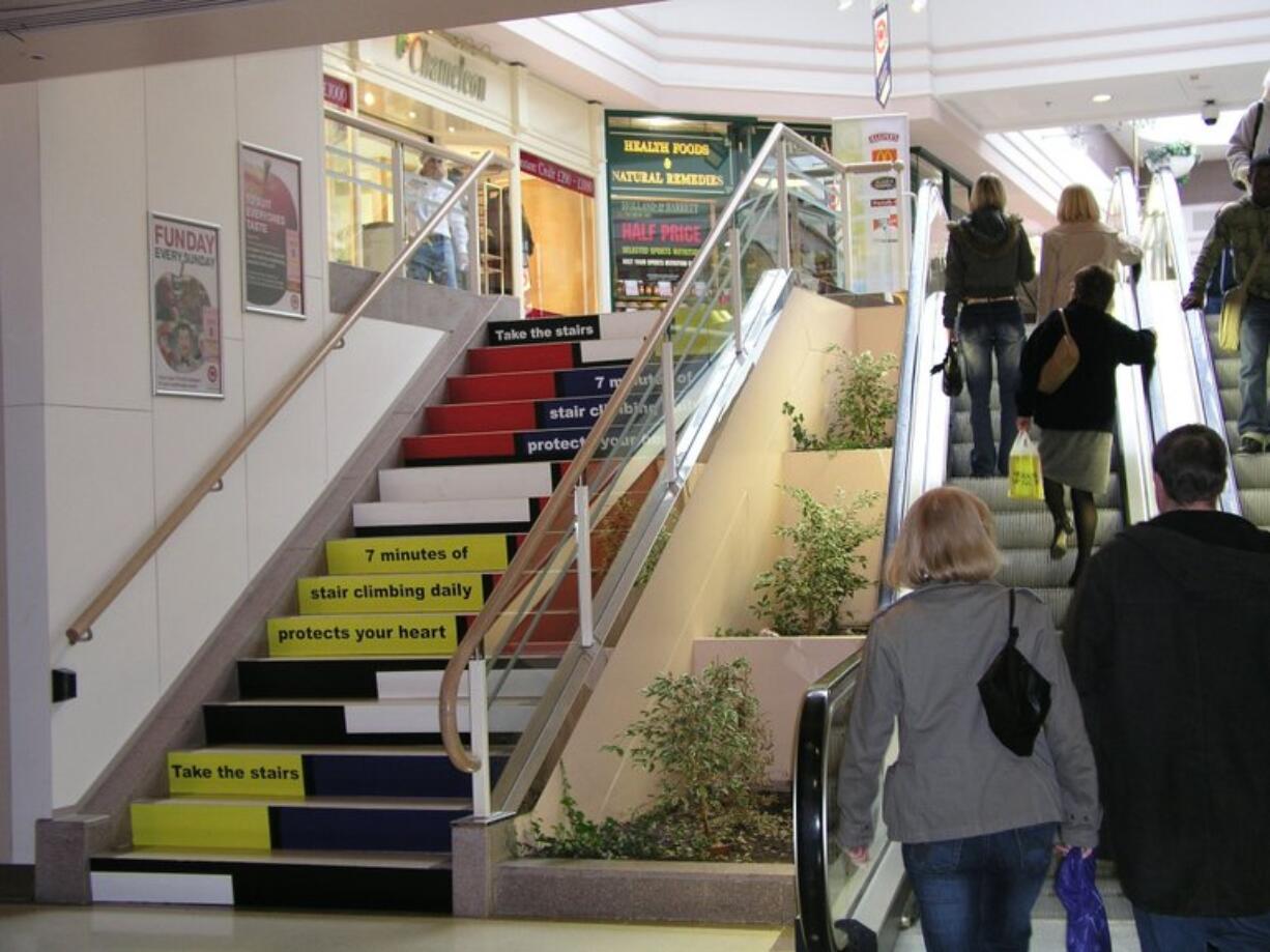 Shoppers use an escalator next to stairs at a shopping mall in Coventry, England.