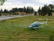 A helicopter sits where it landed Wednesday morning in a wetlands area near the 19400 block of Southeast 192nd Avenue in Vancouver.