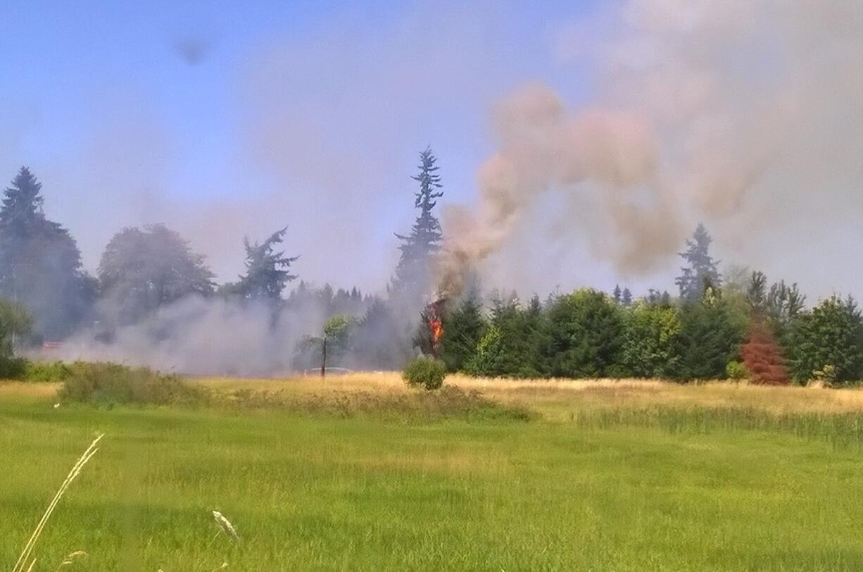 Fire burns in a field near the intersection of Padden Parkway and Andresen Road in Vancouver on Saturday.