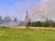 Fire burns in a field near the intersection of Padden Parkway and Andresen Road in Vancouver on Saturday.