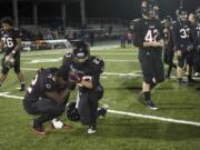 Camas High's Kamari Brown (32), center left, is consoled by teammate Vincente Huber (23) after an overtime loss to Lakes at Doc Harris Stadium in a 3A quarter final game on Friday November 19, 2010.