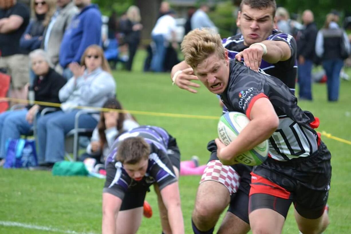 Brendon Curle, who scored three tries in the game, pulls away from a Portland Pumas tackle during the Union High School rugby team's win in the Oregon Rugby state semifinal.