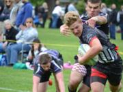 Brendon Curle, who scored three tries in the game, pulls away from a Portland Pumas tackle during the Union High School rugby team's win in the Oregon Rugby state semifinal.