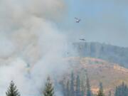 Crews battle a wildfire from the air Sunday as it burned northeast of Woodland near state Highway 503 and Fredrickson Road.