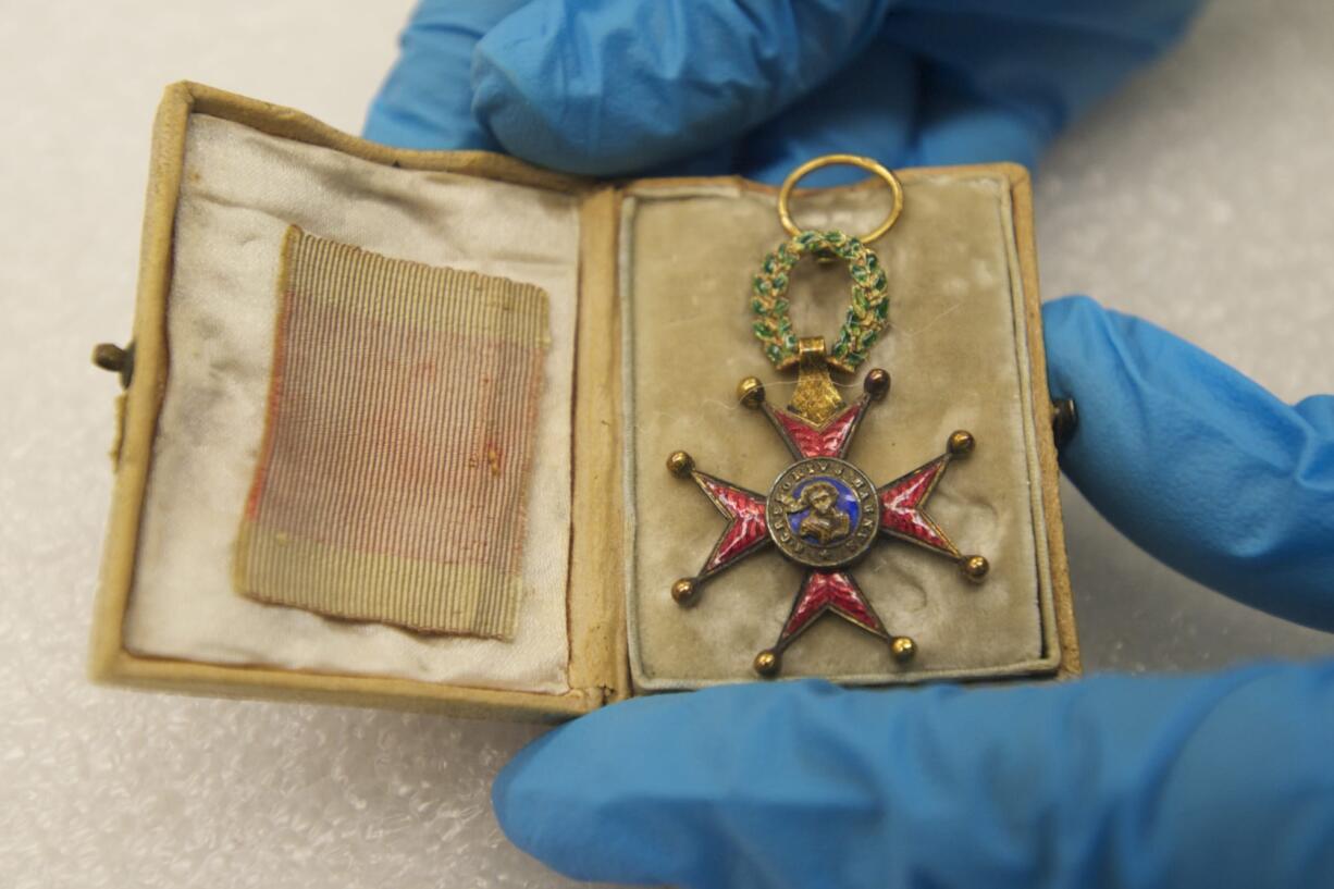 Fort Vancouver museum technician Meagan Huff displays a medal sent by Pope Gregory XVI to John McLoughlin after naming him a Knight of the Order of St.