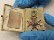 Fort Vancouver museum technician Meagan Huff displays a medal sent by Pope Gregory XVI to John McLoughlin after naming him a Knight of the Order of St.