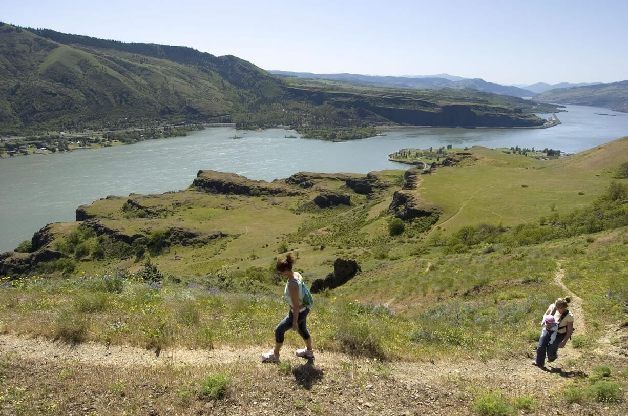 Heleen Kerkhoff, left, of the Netherlands and her sister, Susan Parsons, carrying her 4-month-old daughter, Casey, of Hood River, hike on the first mile of the Cherry Orchard Trail in May 2006.