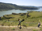 Heleen Kerkhoff, left, of the Netherlands and her sister, Susan Parsons, carrying her 4-month-old daughter, Casey, of Hood River, hike on the first mile of the Cherry Orchard Trail in May 2006.